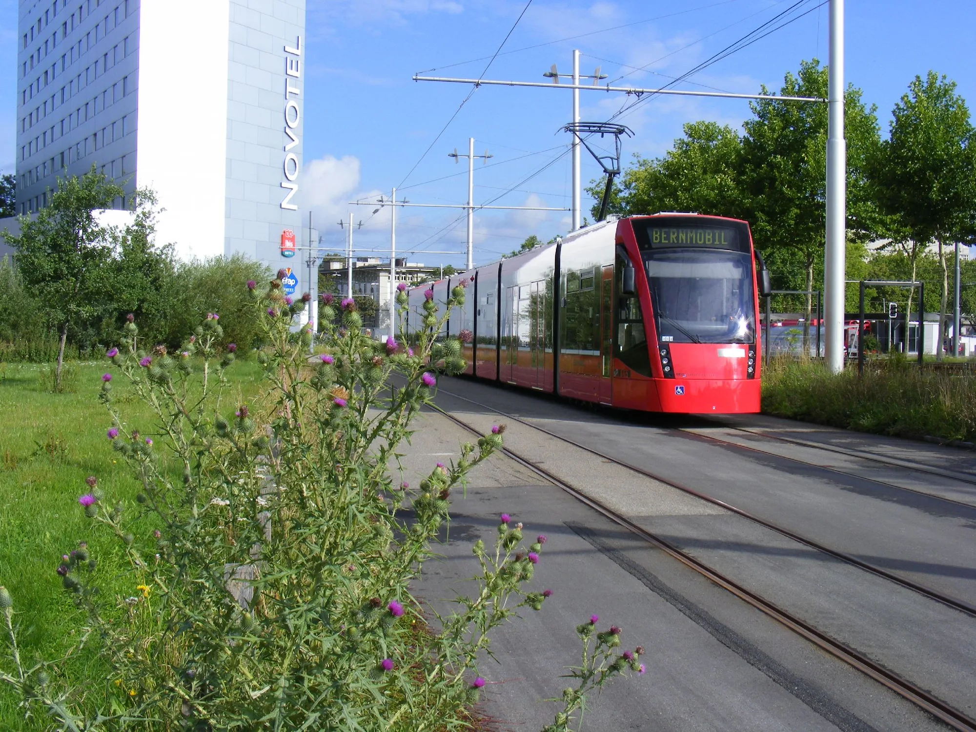A red Bernmobil tram on the tracks in Bern