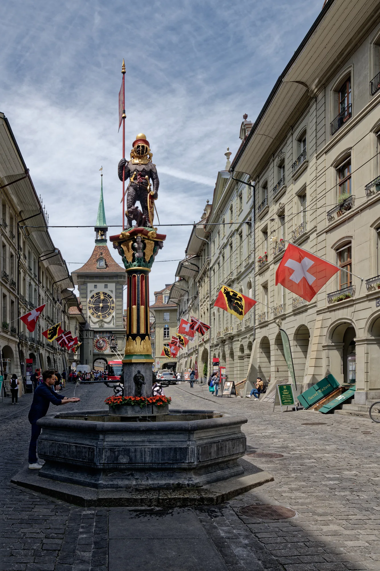 The Zähringerbrunnen on Kramgasse — a bear in armour atop a painted column, with the Zytglogge clock tower behind